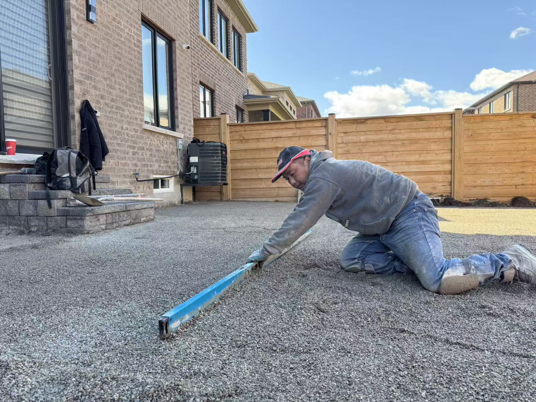 Worker screeding bedding sand to a perfectly flat plane